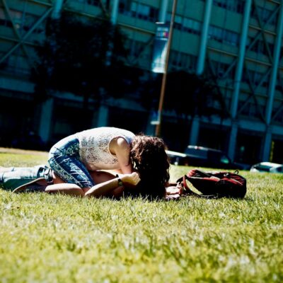 Man and Woman Lying on Green Field